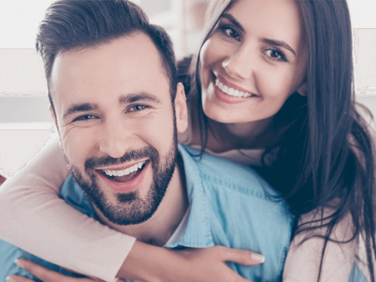 Smiling couple showing confidence after dental bridge treatment