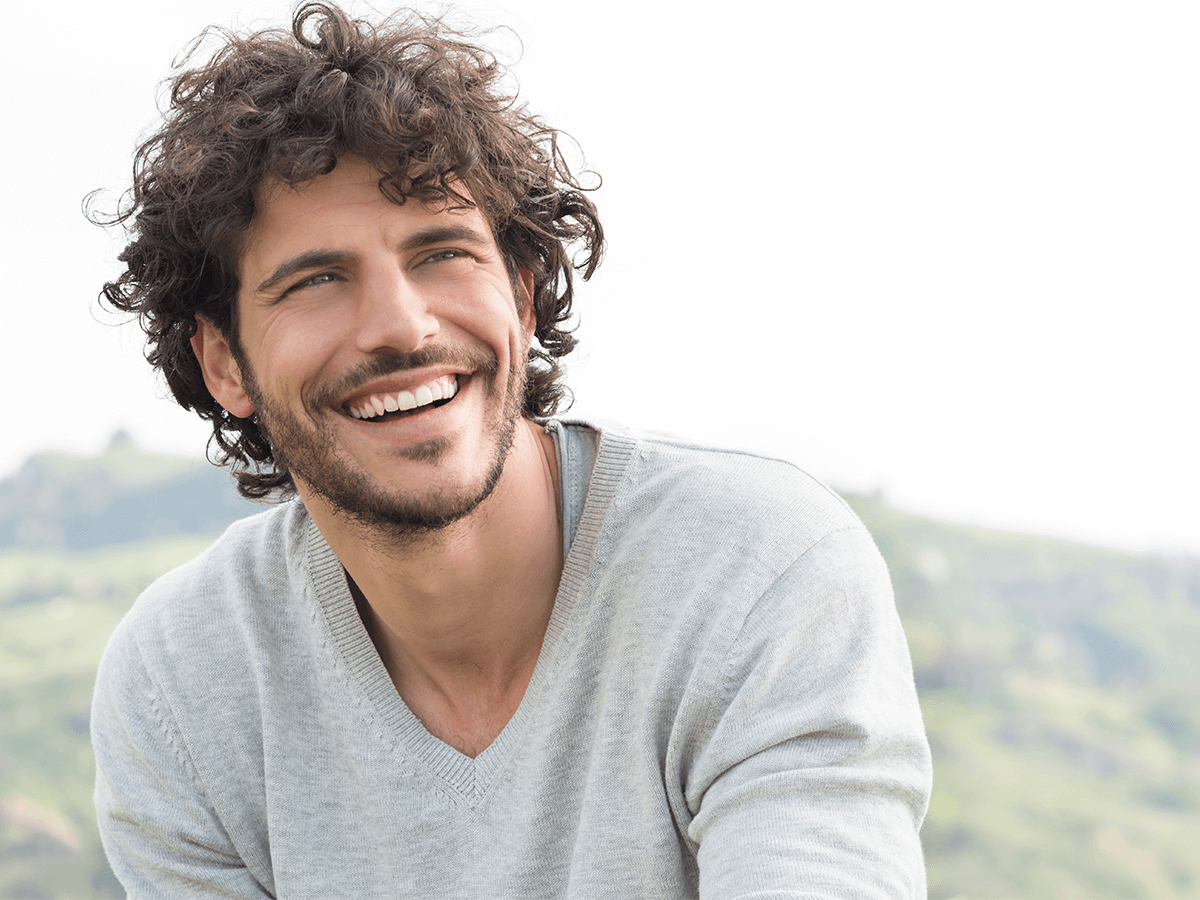 Smiling man showing confidence after dental crown treatment